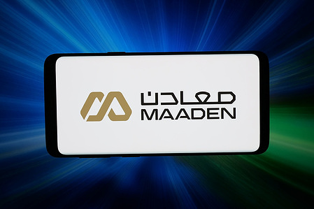 In this photo illustration, the logo of Saudi Arabian Mining Company (Maaden) is seen displayed on a smartphone in front of an abstract background on a computer screen.
