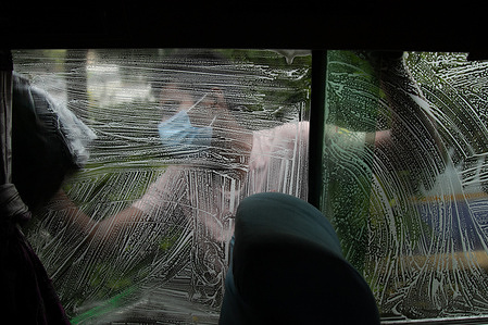 A bus staff wearing a mask cleans his bus before taking on passengers after the long distance public transportation restriction lift.
Nepal government resumes long distance public transport services after 178 days’ restriction due to COVID-19 pandemic starting September 17. The government has decided to allow public transport with only 50 percent of each vehicle seats being occupied so as to observe social distance as a precaution against coronavirus.