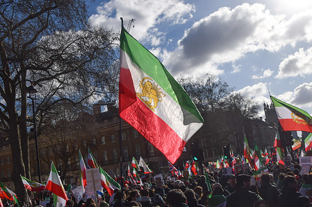 Protesters hold Iranian flags with the lion and sun emblem during the demonstration outside Downing Street against the Islamic Republic and in support of Reza Pahlavi, the Crown Prince of Iran.