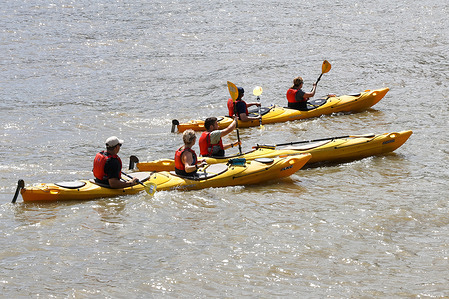 People seen kayaking on the River Thames on a warm day in London.