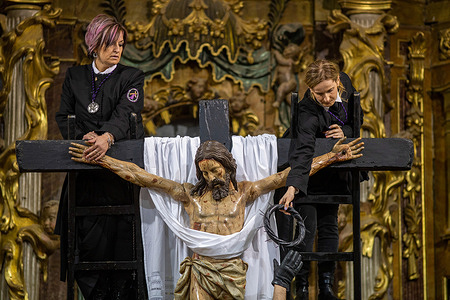 A woman hands over the crown of thorns after removing it from the image of the crucified articulated Christ, during the act of Unclapping at the Mass of the Holy Burial in the church of San Lorenzo in Sahagun.