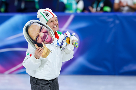 Arianna Fontana of Italy celebrates and poses for a photo with her gold medal and a face mask of herself during the Short Track Speed Skating Podium Mixed Team Realy of the Milano Cortina 2026 Winter Olympics at Milano Ice Skating Arena in Milan.