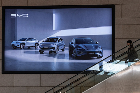 A woman passes by a BYD billboard in Seoul. BYD is the Chinese automotive Company manufacturing passenger battery electric vehicles (BEVs), plug-in hybrid electric vehicles (PHEVs) and new energy vehicles (NEVs).