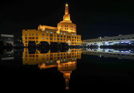 A reflection of the Sheikh Abdullah Bin Zaid Al Mahmoud Islamic Cultural Center building on a rainy day in Doha.