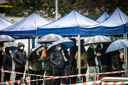 Hong Kong residents queue in the rain to receive their COVID-19 tests. 
Hong Kong is well into the fifth wave of COVID-19 with the testing and health care systems overwhelmed due to thousands of new cases. Compulsory testing orders have been issued across the city, with hundreds of residents standing in the cold rain awaiting their turn.