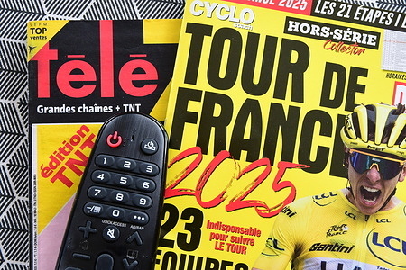 In this photo illustration, a magazine of the 2025 Tour de France cycling race from the publisher Cyclo Coach and television remote control seen displayed.