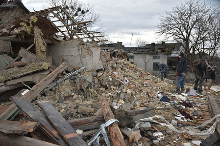 People sort through the rubble of a destroyed building after a Russian missile hit a civilian residential area.