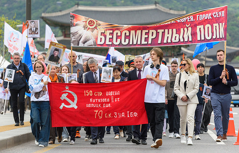 Russians march with a Soviet victory banner during the Immortal Regiment (Bessmertny polk) march to mark the upcoming Victory Day. The Immortal Regiment (Bessmertny polk) is a massive civil event in major cities around the world every May 9 during the Victory Day celebrations. It involves people carrying on the memory of war veterans with participants carrying pictures of relatives or family friends who served in the country's labor sector, paramilitary units, the Soviet Armed Forces and law enforcement organizations during the Second World War.