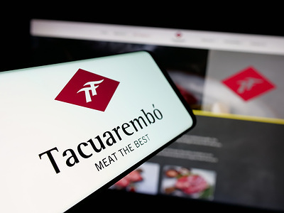 In this photo illustration, a smartphone with the logo of meet company Frigorifico Tacuarembo S.A. is seen on screen in front of website.
