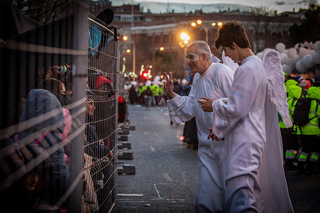 A pair of extras dressed as angels greet children during the celebration of the Three Wise Men parade in Madrid. Like every January 5, the traditional parade of the Three Wise Men of the East was held on the Paseo de la Cstellana in Madrid, who brought gifts to the children.