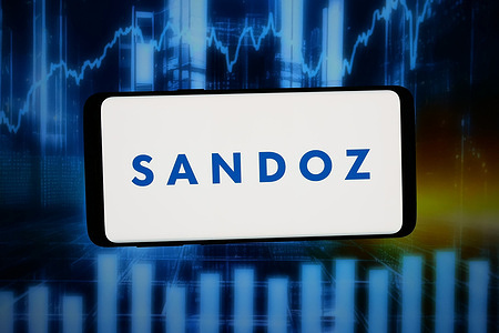 In this photo illustration, the logo of Swiss pharmaceutical company Sandoz Group AG is displayed on a smartphone in front of abstract background on computer screen.