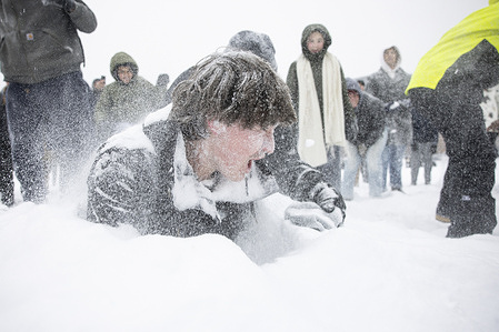 People play in the snow at the National Mall as heavy snowfall blankets. A massive winter storm is expected to bring frigid temperatures, ice, and snow to millions of Americans across the nation.