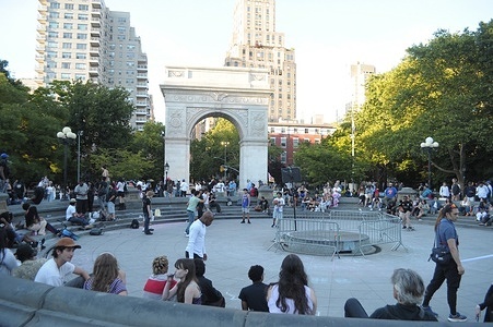 People sit around an empty water fountain in Washington Square Park, Manhattan, New York City.