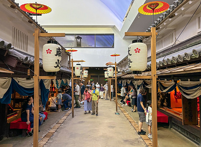 Visitors during their visit to the Osaka Museum of Housing and Living in Japan. The Osaka Museum of Housing and Living in Japan features life-sized recreations of Osaka streets and houses from the Edo to Showa periods, showcasing the evolution of the city's urban life and architecture. Visitors can experience historical daily life through interactive exhibits and seasonal displays, offering a vivid glimpse into past living conditions and culture.