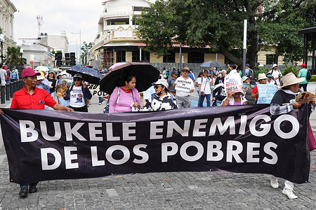 Protesters with a banner chant slogans against the government of Nayib Bukele during a labor day protest.