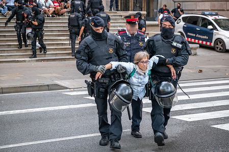 Two policemen from the Mossos d'Esquadra evict a demonstrator from the Catalan pro-independence group who occupied the steps of the Superior Court of Justice of Catalonia.
A new protest action organized by the Committees of Defense of the Republic of Catalonia (CDR) demanding the prosecutor to drop the prison sentences for the 14 pro independence detainees who are sent to prison as they were protesting against the Spanish state.