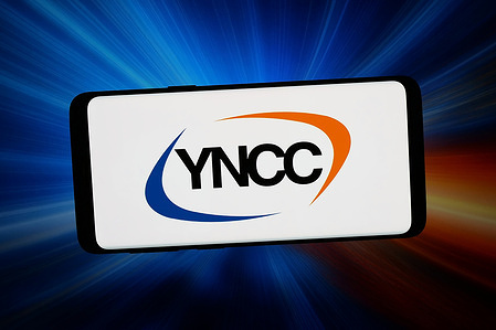 In this photo illustration, the logo of Korean company Yeochun NCC Co. Ltd. (YNCC) is displayed on a smartphone in front of abstract background on computer screen.