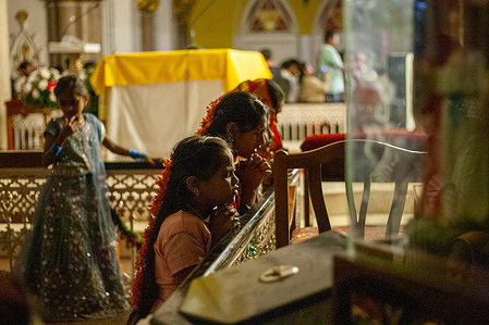 Girls seen praying during a Christmas Mass at St. Mary’s Basilica church.
