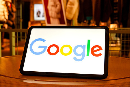 In this photo illustration, the Google logo is seen displayed on the screen of a tablet.