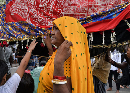 A Hindu woman takes blessings from a replica of the coffin of Prophet Mohammed to seek blessings during a Muharram procession to mark Ashura. Shia Muslims perform mourning ritual during Muhharum procession to mark Ashura. Ashura is an important Islamic day which falls on the 10th day of month of Muharram, the first month of Islamic lunar calendar. Ashura marks the death of Husayn ibn Ali, the grandson of prophet Muhammad in the battle of Karbala. The day is observed as the end of 10 days of mourning.