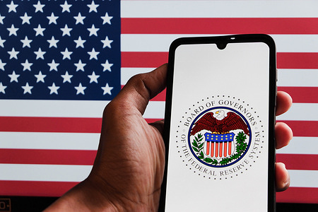 In this photo illustration, The Federal Reserve System logo displayed on a smartphone.