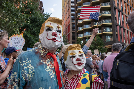 A couple have clown Trump's masks on during the demonstration. Protesters gathered for the "No Kings" protest by the US Embassy in London, UK. The demonstration was organised by the Democrats Abroad group for the 79th birthday of US President, Donald Trump to oppose his policies and actions during his second presidency.