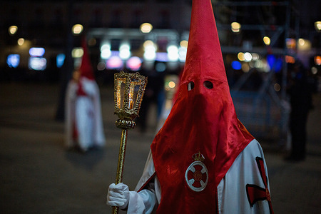 A Nazarene from the Brotherhood of Our Father Jesus the Divine Captive carries a candelabra through the streets of Madrid during the procession of the Divine Captive on Good Friday. Seven processions took to the streets of Madrid on Good Friday night.