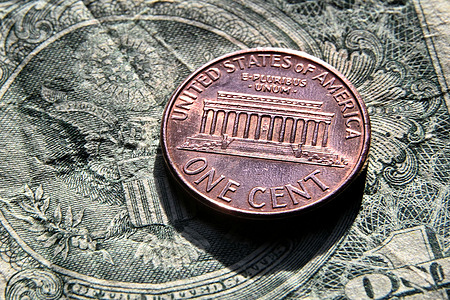 In this photo illustration, an American one-cent coin viewed on a US one-dollar bill. President Donald Trump ordered the Treasury to stop minting pennies because their production cost exceeds their value.