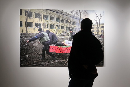 A man looks at a photograph of rescuers carrying a pregnant woman after the bombing of a maternity hospital in Mariupol by photographer Evgeniy Maloletka, who became the winner of World Press Photo, presented at the exhibition. An exhibition of photographs from the World Press Photo competition is taking place in Kyiv.
