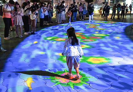 A girl walks on eco-friendly digital krathongs, or floating baskets, on a projected river on the Pathumwan Skywalk during the festival. Loy Krathong is a Thai festival celebrated annually on the full moon of the 12th month in the traditional Thai lunar calendar. The festival is believed to have links to Hindu traditions.