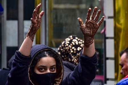 A Kashmiri Muslim girl raises her henna-painted hands, as she walks through the busy market, ahead of the Muslim festival Eid al-Fitr. Markets across the Muslim world witness huge shopping rush in preparation for Eid al-Fitr, a celebration that marks the end of the Muslim fasting month of Ramadan.