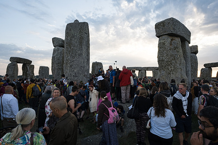 People gather at Stonehenge celebrating summer solstice. Thousands of people attended the annual festival and watched sunrise celebrating the summer solstice at Stonehenge which signifies the end of spring.