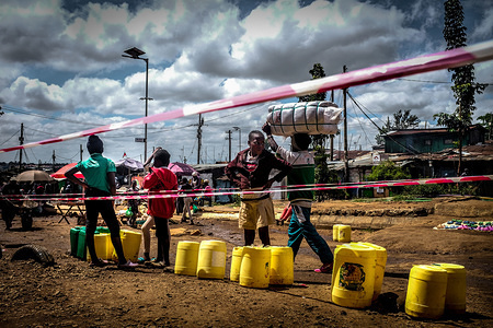 NAIROBI, KENYA - MAY 05, 2020: A long queue of cans at a water fetching point during the scarcity of water amidst the ongoing Curfew due to the corona virus pandemic.
Across most neighborhoods and the streets of Kibera, local residents are seen wandering around carrying their empty water cans in search of water while some have to queue up for a long period of time in parts where there is access to water.