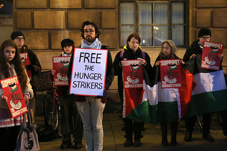 Protesters hold signs saying ‘Free The Hunger Strikers’ and ‘Support The Hunger Strike’ during the vigil. Supporters of the Filton 24 remand prisoners hold a vigil for the seven hunger strikers refusing food in jails across the UK. Several prisoners have refused food for 43 days. Despite five being hospitalised the government is refusing to engage with them. The prisoners have been on remand for over a year since being arrested for targeting the Filton site of Israeli arms company Elbit Systems in Bristol and destroying quadcopter drones they say were destined for use against Palestinians in Gaza. The hunger striking prisoners are making five demands of the government : to end all censorship and surveillance of communications, immediate bail, a fair trial, de-proscription of Palestine Action and to shut down Elbit Systems.