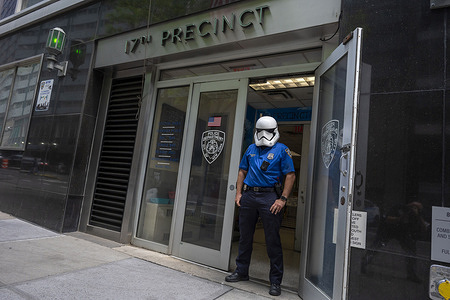 New York Police Department Officer Dennis Wyss wears a Star Wars Stormtrooper Helmet at the entrance to the 17th Precinct celebrating Star Wars Day, an unofficial global fan event held annually on May 4th, chosen as a play on words with "May the Forth" and the legendary Star Wars sci-fi movie series' iconic line, "May the Force be with you," in New York City. arts culture and entertainment, clothing, cosplay, costume, fan, fan - enthusiast, film industry, full length, helmet, lifestyles, manufactured object, movie, new york city police department, nypd, police officer, recreational pursuit, retail, star wars, stormt rooper, stormtrooper, stormtrooper - star wars, television show, horizontal, photography, day, daytime, out, outdoors, outside, business, business finance and industry, corporate business, economy, environment, finance, finance and economy, politics and government, manhattan, borough, city, city life, new york, new york city, new york state, ny, nyc, 2025, america, american, color image, east coast, m10s, mid-atlantic, national, north america, radar, ron adar, the americas, united states, us, usa