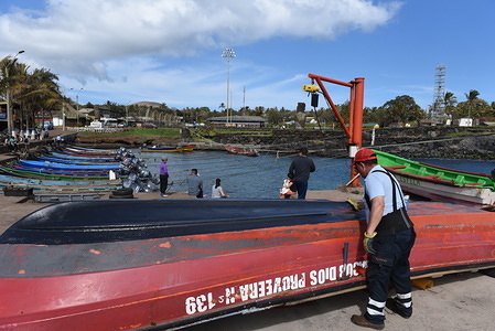 A fisherman is seen painting his boat at the fishing port.
Hanga Roa is the capital of Easter Island, a Chilean island in the southeastern Pacific Ocean. The village has around 5,000 inhabitants, which comprises between 87 and 90 percent of the total population of the island. Excluding a small percentage still engaged in traditional fishing and small-scale farming, the majority of the population is engaged in tourism which is the main source of income.