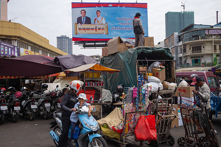 A billboard with a poster of former Cambodian Prime Minister Hun Sen and current Prime Minister Hun Manet seen at Orussey Market.