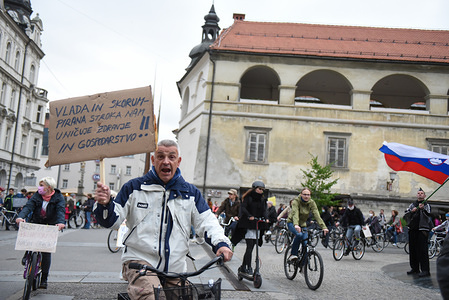 A man holds a placard that says The government and corrupt advisors are ruing our health and economy during the anti-government protest at the Trg Svobode square (Liberty square).
For the fourth Friday in a row, protests against the government and Prime Minister Janez Jansa were organized in several Slovenian cities. Protesters are accusing the government and the prime minister of corruption, undemocratic rule, media restrictions and using the COVID-19 (the novel coronavirus) crisis to restrict freedom and human rights. More than 500 people gathered in Maribor.