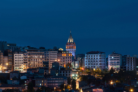 View of the Istanbul skyline with the iconic Galata Tower lit up at night on the European side of the Bosporus straight, Turkey.