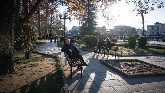 People are seen seated at the main square in Trikala in northwestern Thessaly in Greece.