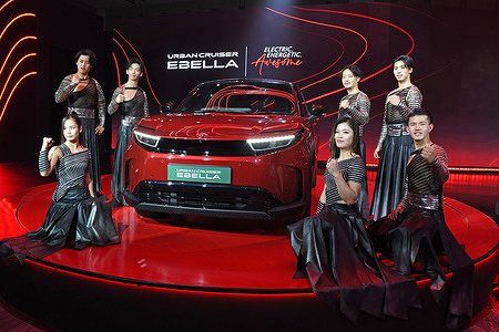 Drum Tao performers seen posing for a photo with Toyota electric Urban Cruiser Ebella car during the launch event.