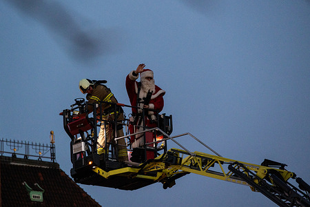A man dressed as Santa Claus waves to the audience as he lights a Christmas tree at the City Hall Square. Copenhagen is celebrated for its stunning Christmas light displays, and this year, Santa Claus added a magical touch by lighting fireworks on Christmas trees during a special ceremony, creating a memorable experience for visitors.
