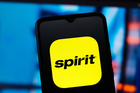 In this photo illustration, the Spirit Airlines logo is seen displayed on a smartphone screen.