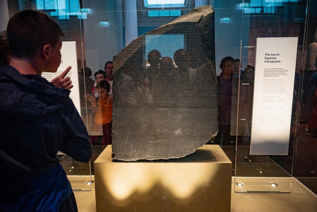 Tourists gather round the Rosetta Stone on display in the British Museum, London.
The ancient Egyptian stele is key to deciphering hieroglyphic script.