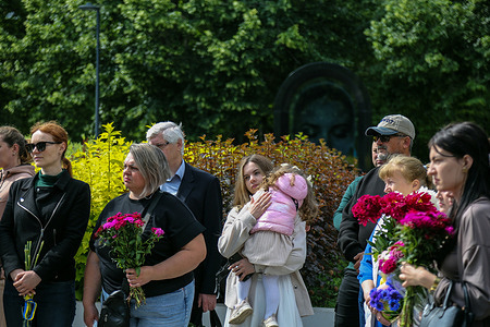 People seen with flowers at the "Bell of Memory" memorial event at "Glory and Freedom" square. The traditional "Bell of Memory" event is held in memory to "Fighters for Ukraine" in the "Glory and Freedom" square. The event traditionally takes place on the last calendar day of the month. During the event, the names of all those who died in the last month during the 11 years of the Russian-Ukrainian war are remembered.