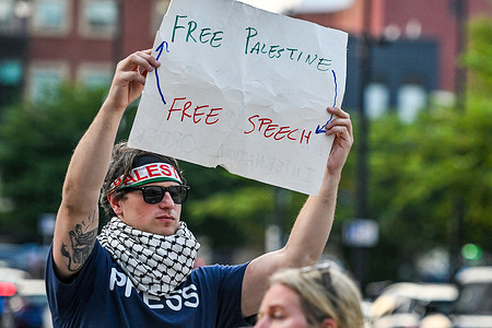 A protester holds a placard that reads "Free Palestine, Free Speech" during a protest against the war in Palestine. Outside a Pennsylvania television news station, a protester called attention to the deaths of more than 250 journalists in Gaza, urging local media to cover the ongoing toll on press freedom and human lives.