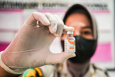 A police officer holds a sinovac, Covid-19 vaccine vial for vaccinating disabled persons at the vaccination booth in Mandonga police station.The Kendari police vaccine booth held a vaccination operation for people with disabilities at the Mandonga police station in Kendari. Dozens of disabled persons were picked up at their respective homes using Police operational vehicles for their first dose of the Sinovac, Covid-19 vaccine.