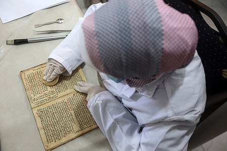 A Palestinian woman specializing in conservation, restoring, and digitizing manuscripts and rare books works at a laboratory within the 'Eyes on Heritage' Foundation for Studies, Research, and Publishing in Gaza City. Palestinian women work on archiving and restoring rare historical manuscripts and books in a laboratory funded by the British Library in London and the Hill Museum.