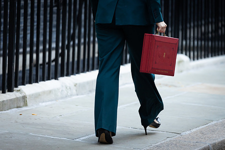 Chancellor of the Exchequer Rachel Reeves walks off with the red budget briefcase in Downing Street. Reeves is expected to avoid raising income tax as previously speculated, but instead will spend more on public services and raise taxes from other minor sources to fill the gaps in Britain’s ailing public finances.