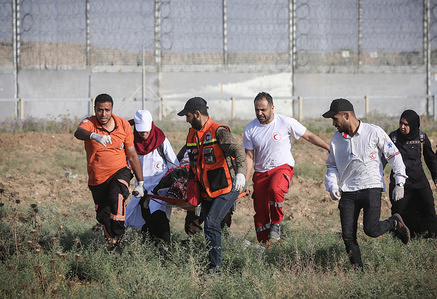Medics carry an injured Palestinian during the clashes following the "Great March of Return" demonstration in Shuja'iyya neighborhood of Gaza City, Gaza.